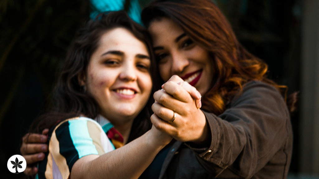 an image of Latin women holding hands smiling